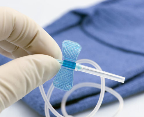 28837366 - nurse holds small blue butterfly catheter.